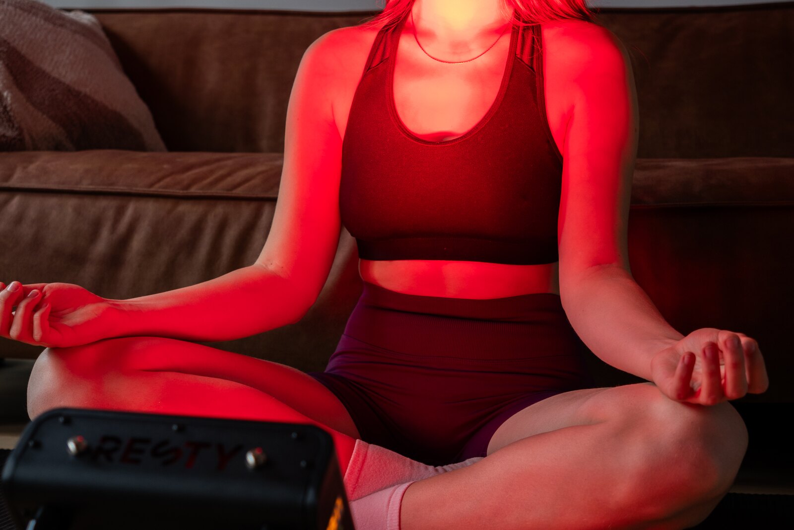Mujer usando un panel de luz roja Resty MARS en casa