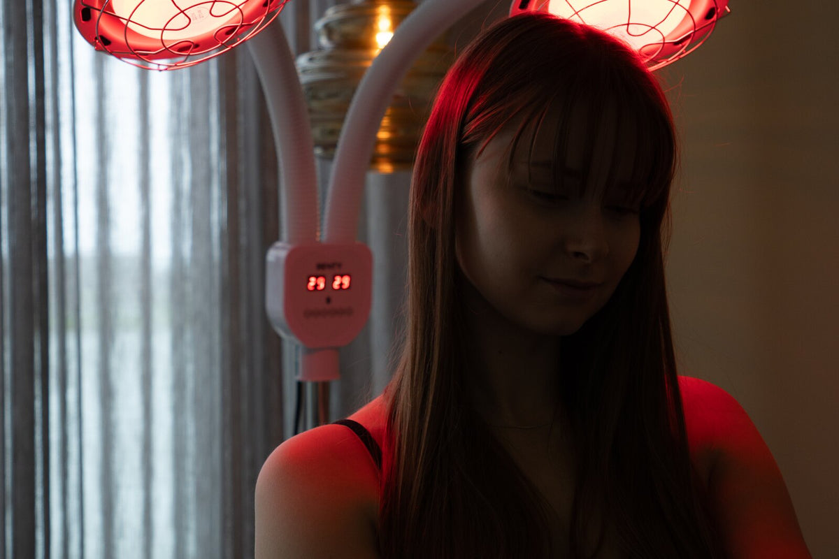 Woman using a Resty red light heat lamp at home