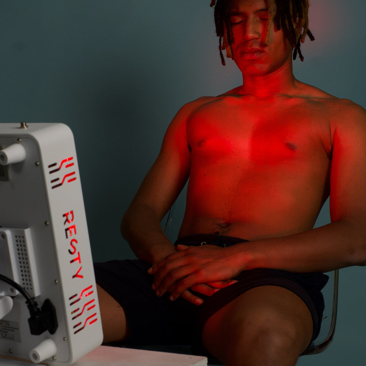 Man seated in front of a Resty MARS 600 red light panel