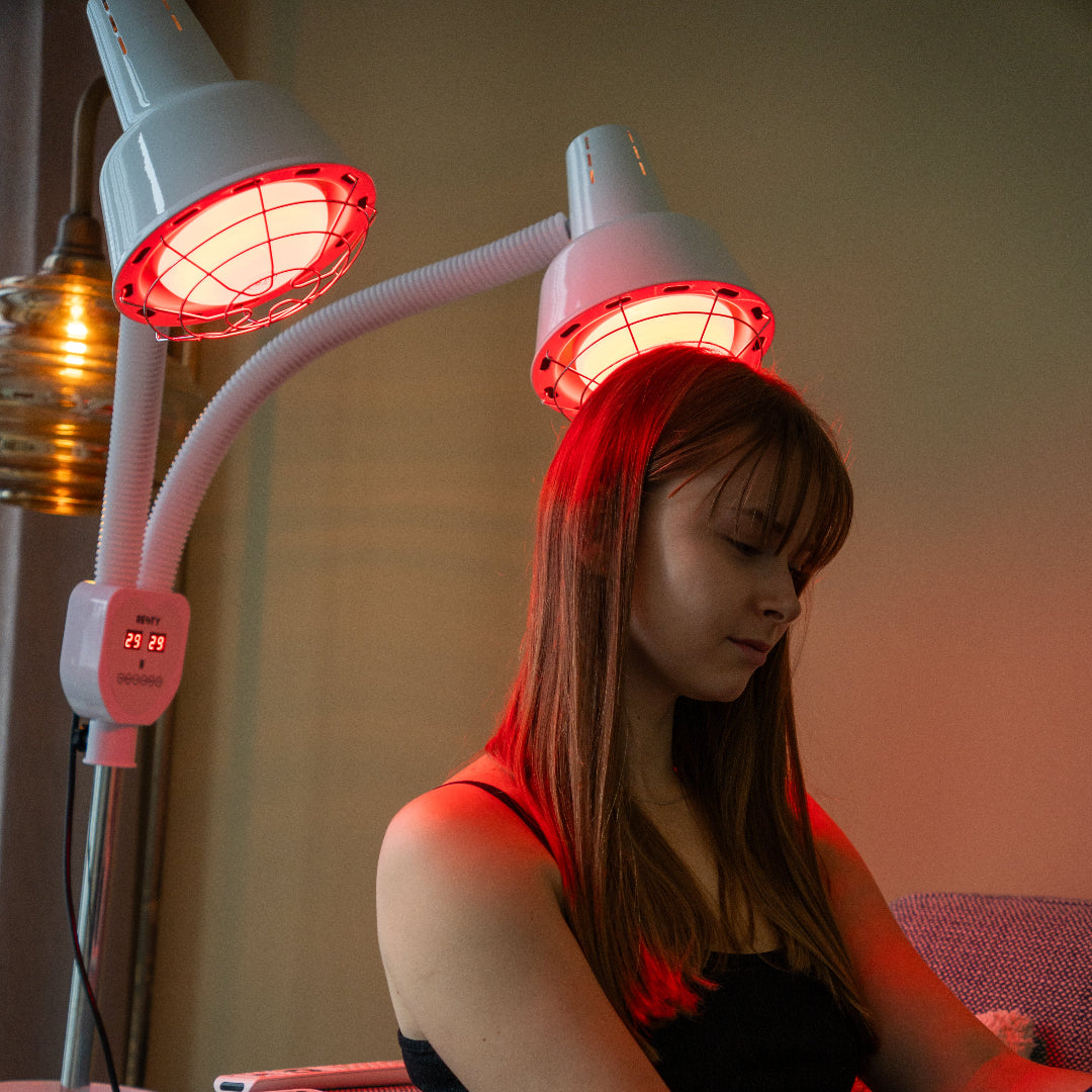 Person using a Resty infrared heat lamp near the head and shoulders
