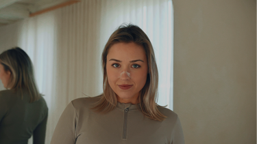 Eine blonde Frau trägt ein transparentes Nasenpflaster