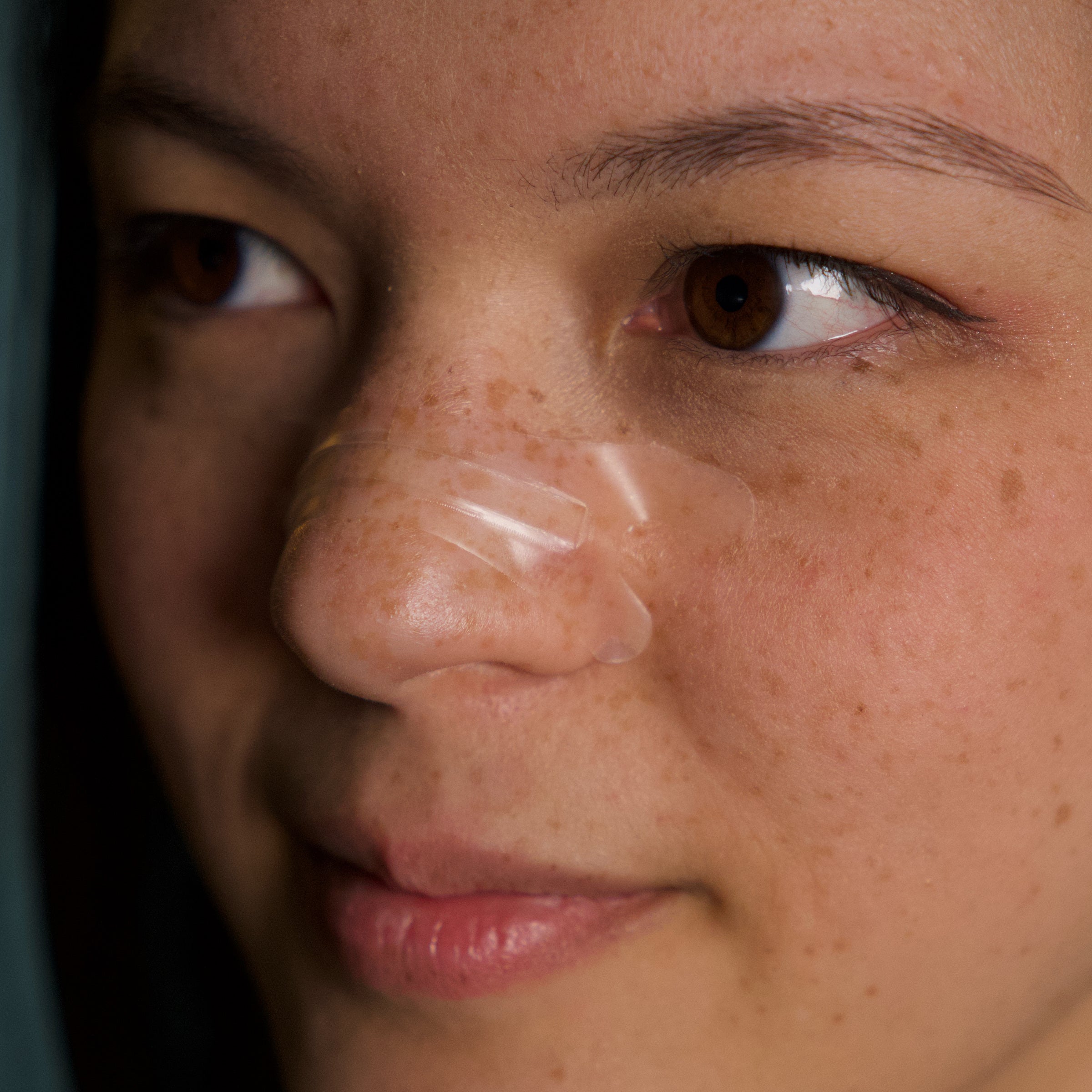 Transparent Resty nasal strip worn on the nose in a real close-up